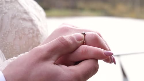 1. Der Bräutigam berührt sanft den Ehering an der Hand der Braut. Liebe und Emotionen.
