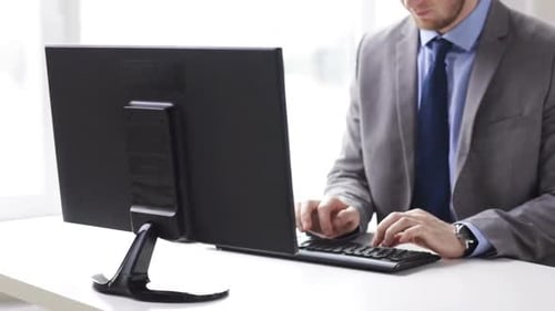 Businessman hands typing on computer keyboard in modern office workplace