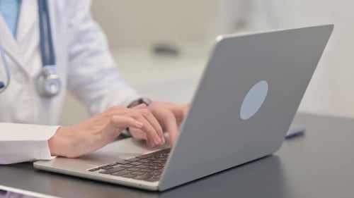 Close up of Female Doctor Typing on Laptop