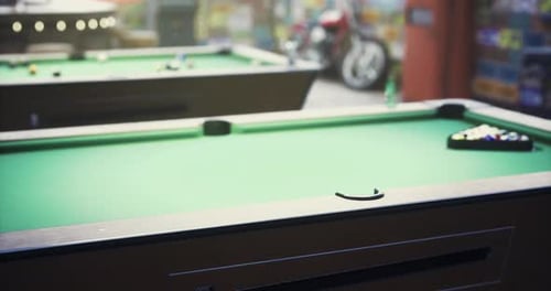 Billiard Tables with Vibrant Green Felt in a Lively Game Setting