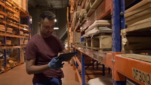 Worker Using Digital Tablet in Distribution Warehouse Adult