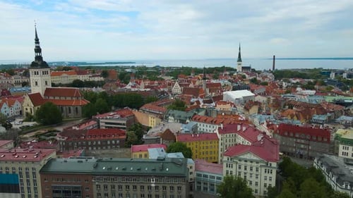 Aerial view of a historic medieval old city in Tallinn Estonia during a cloudy day, church towers.