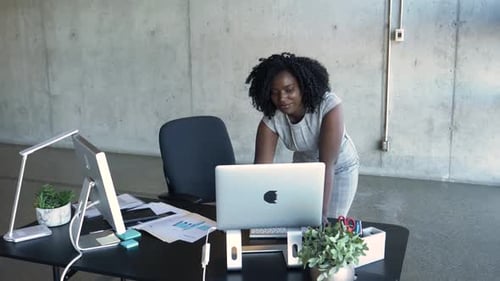 Junge Geschäftsfrau arbeitet fleißig an ihrem Laptop in einem modernen Büro