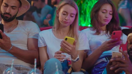 Friends Using Phones at Night in Urban Setting