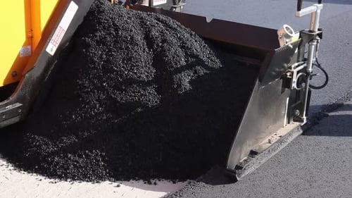 Road Construction Workers Laying Asphalt on New Street in Residential Area