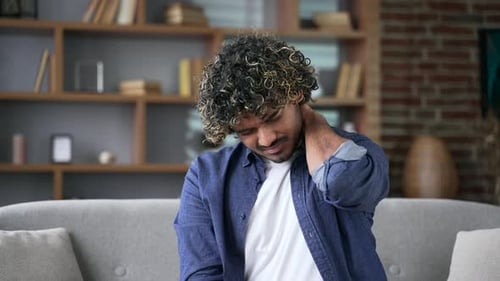 Man Rubs Neck in Discomfort