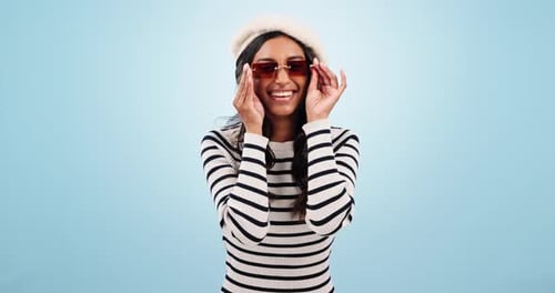 Fashion, sunglasses and woman wink in studio with trendy outfit, clothes and stylish accessories