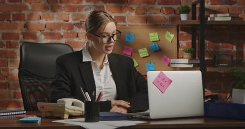 Young Businesswoman in Office with Brick Wall Background