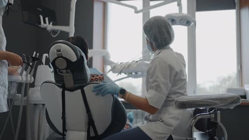 Female Doctor In Dental Clinic Working With Patient In Office Sterile Room For Curing Treatments