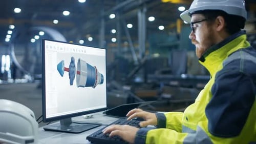 Inside the Heavy Industry Factory Industrial Engineer Works on the Personal Computer Designing Turb
