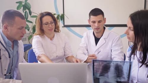 Team of Four Doctors Discusses the Results Chest XRay Scan of Patient in Consulting Room of Hospital