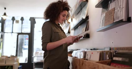 Young Adult female holding record in a store