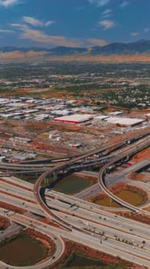 Complicated system of roads in Salt Lake City. Vast city scenery at backdrop of mountains at daytime