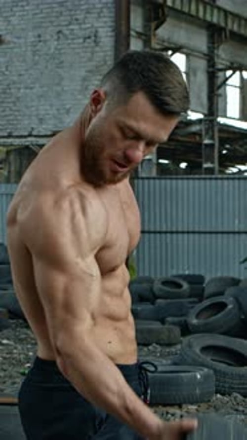 Man training with tire. Muscular fitness man training with old tire wheel