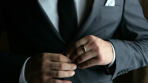 Man Buttoning a Stylish Gray Suit Jacket