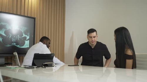 Doctor Discussing Brain Scan Results With Young Adults