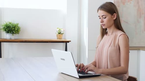 Woman Typing on Laptop Computer at Wooden Table