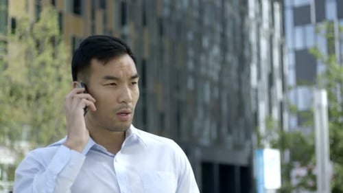 Young Man Talking on Phone in City