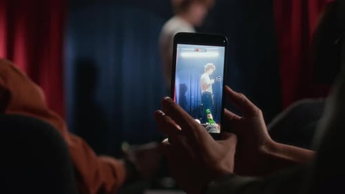 Close-Up of Phone Screen with Video Recording of Comedian on Stage