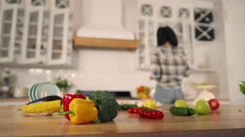 Woman Prepares Fresh Vegetables in Sunny Kitchen