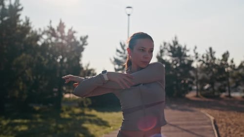 Woman Stretches Arms Outdoors in the Sunlight