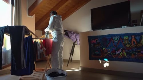 Woman Hanging Clothes on Drying Rack Indoors