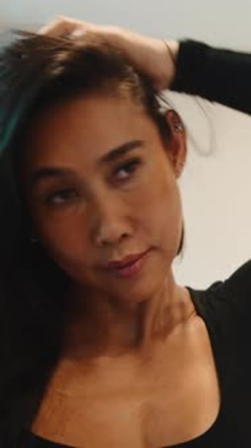 Attractive Woman Runs Hands Through Hair Indoors