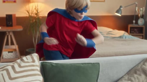 Boy Dressed as Superhero Playing on Couch