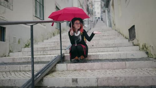 Young Woman Holding Red Umbrella Sitting on Old City Stairs
