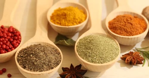 Colorful Assortment of Culinary Spices in Wooden Spoons