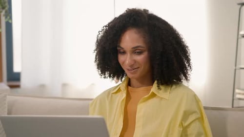 Woman with Curly Hair Using Laptop at Home