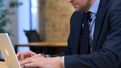 Echtzeit-Video: Kaukasischer Mann arbeitet, sitzt auf seinem Stuhl und tippt auf seinem Computer, er schaut