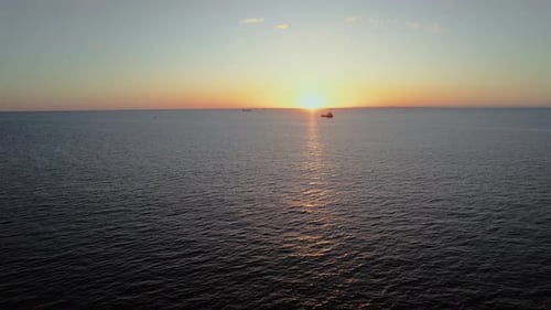 Tranquil Sunset Over the Vast Ocean With Ships on the Horizon