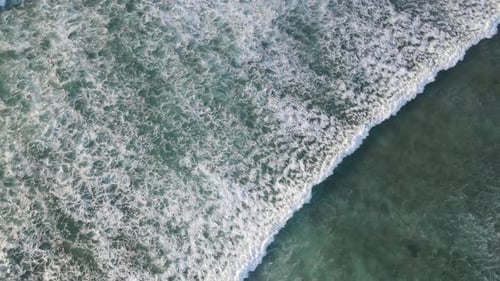 4K aerial top view of waves foam in beautiful turquoise sea texture background
