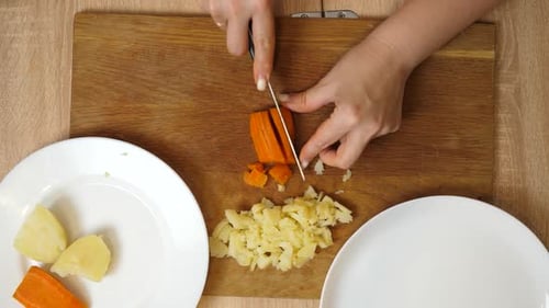 19 1Gekochte Kartoffeln und Karotten werden gehackt. Ein Gemüsegericht wird zubereitet.