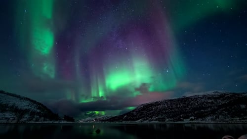 Stunning northern lights over snowy fjord landscape, Skarsfjord, Norway. Time-lapse