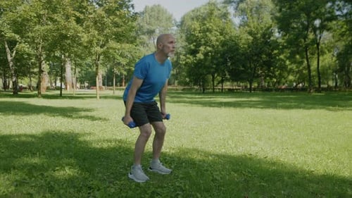 Motivated Sporty Fit Man Doing Dumbbell Triceps Kickback Exercise in Park