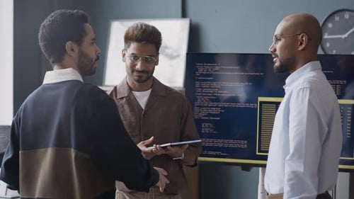Diversos desenvolvedores de software discutindo ideias no escritório de TI