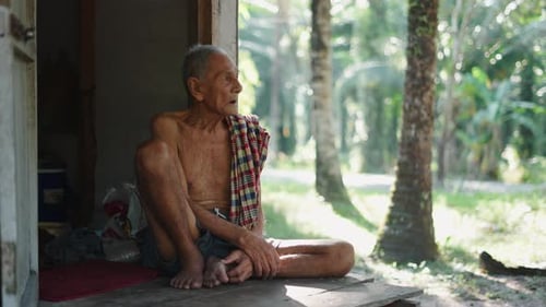 Senior Man Relaxing on Porch in Rural Setting