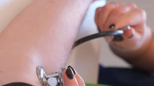 Doctor Examines Patient with Stethoscope Close Up