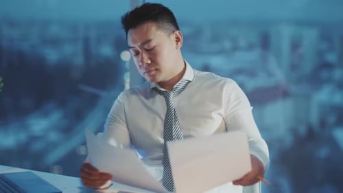 Professional Examining Reports in City Office Business Expert Analyzing Data Amid Urban Nighttime