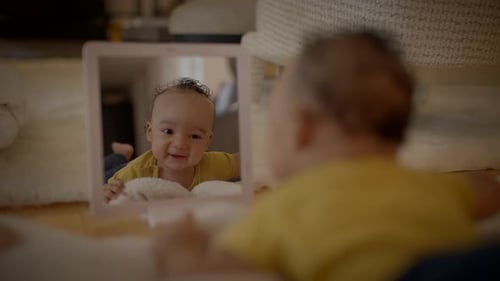 Smiling Infant Looking in a Mirror