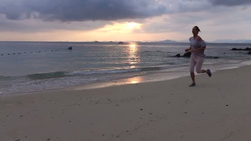 Young Woman Jogging on Beach During Sunset, Super 240