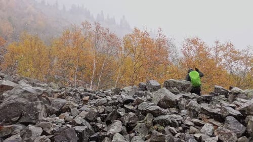 Back View of Male Tourist Climbing on Rock and Showing Two Fingers on His Hand Filmed in Slowmo