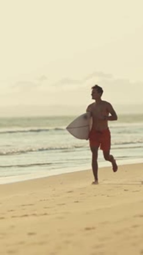 Surfer Running on the Beach at Sunset