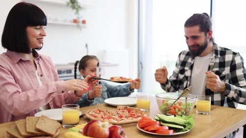 Family Enjoys Pizza and Healthy Meal at Table