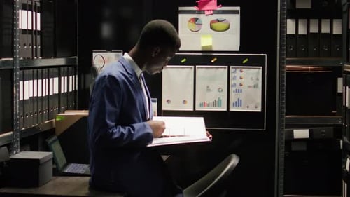 Businessman Analyzing Documents in Dark Office
