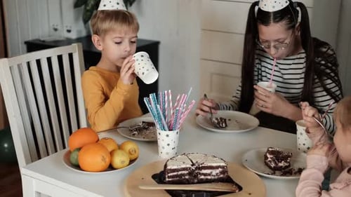 Children Eating Birthday Cake Slice on a Birthday Party at Home Siblings Girls and a Boy Together