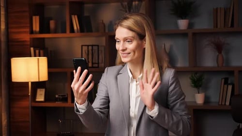 Woman Using Phone for Video Call in Office