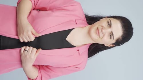 Smiling Woman in Pink Blazer Poses in Studio
